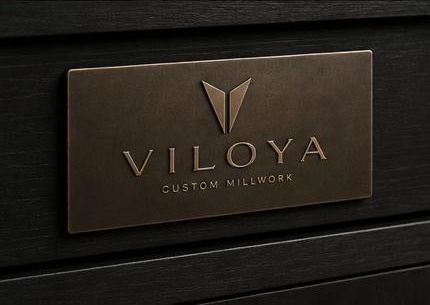 Engraved bronze Viloya plaque set into dark cabinetry